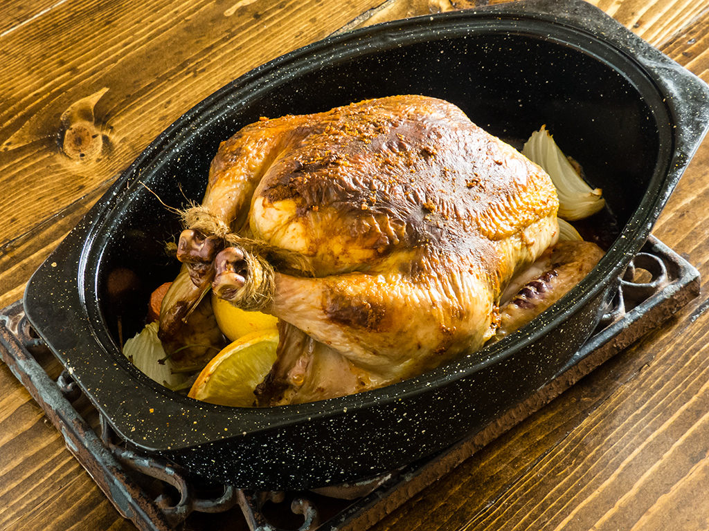 Beautifully browned Berbere roast chicken, in the roasting pan